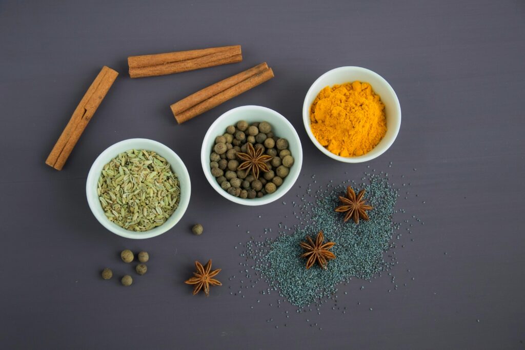 pexels-photo-678414-678414 Flat lay of assorted spices including cinnamon, turmeric, and star anise on a dark surface.